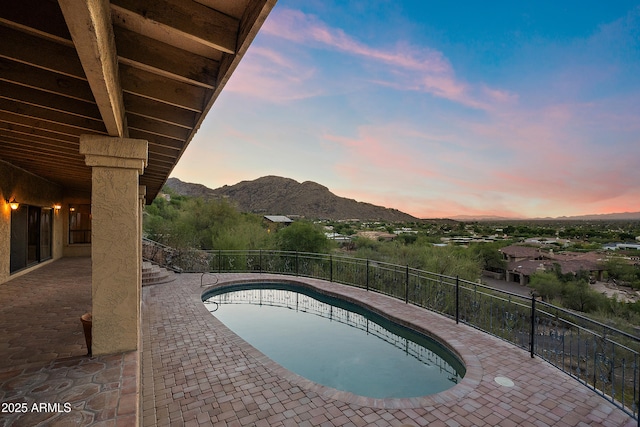 6349 E Hummingbird Ln, Paradise Valley, AZ 85253 - pool at dusk featuring a mountain view and a patio area