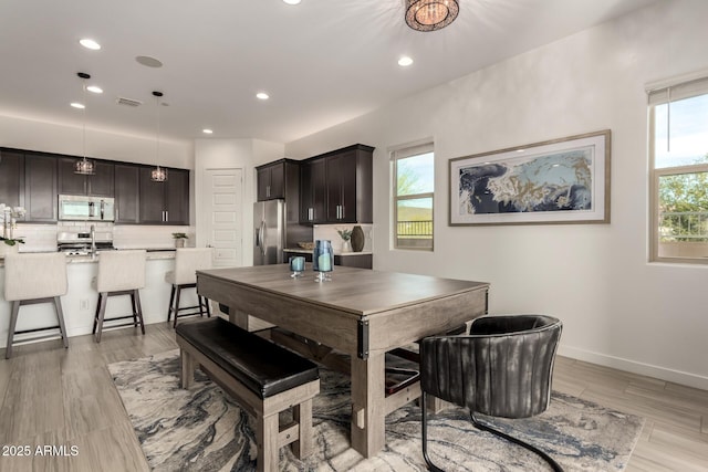 dining area with plenty of natural light and light hardwood / wood-style flooring