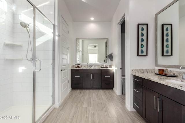 bathroom featuring vanity and a shower with door