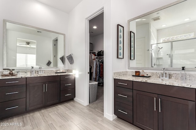 bathroom with vanity, an enclosed shower, and ceiling fan