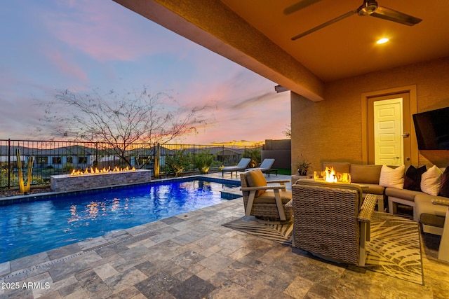 view of swimming pool with a patio, an outdoor living space with a fire pit, and ceiling fan