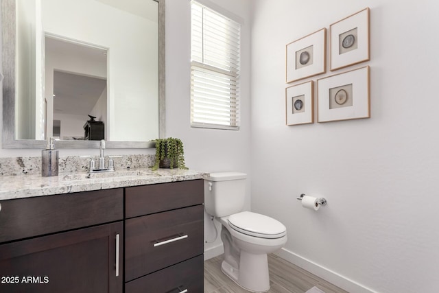 bathroom featuring vanity, hardwood / wood-style flooring, and toilet