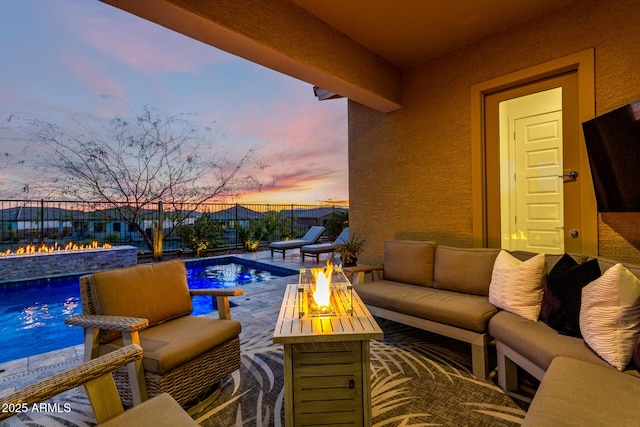 view of pool featuring an outdoor living space with a fire pit and a patio