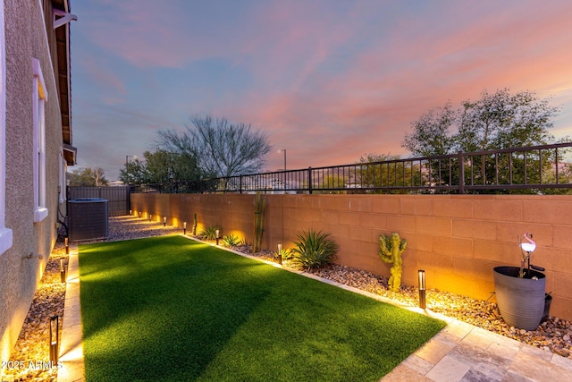 yard at dusk featuring central air condition unit