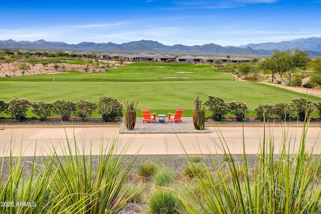 view of community featuring an outdoor fire pit, a mountain view, and golf course view
