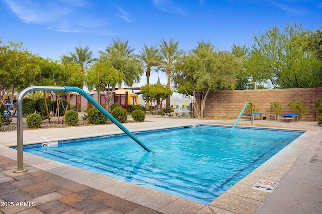 community pool with fence and a patio