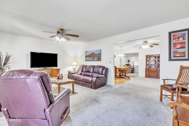 living area with carpet floors, ceiling fan, and a textured ceiling