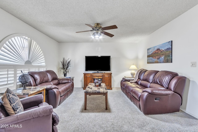 carpeted living area featuring a textured ceiling and ceiling fan