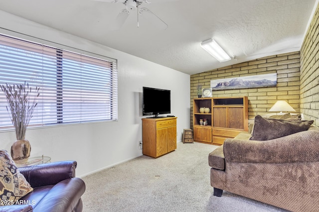 living room featuring light carpet, vaulted ceiling, a textured ceiling, brick wall, and ceiling fan