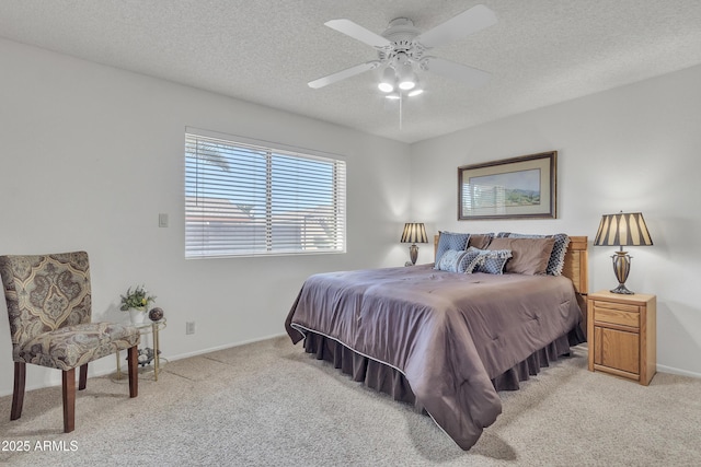 bedroom with light carpet, ceiling fan, a textured ceiling, and baseboards