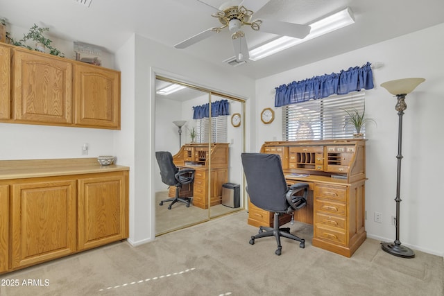 home office with baseboards, a ceiling fan, and light colored carpet