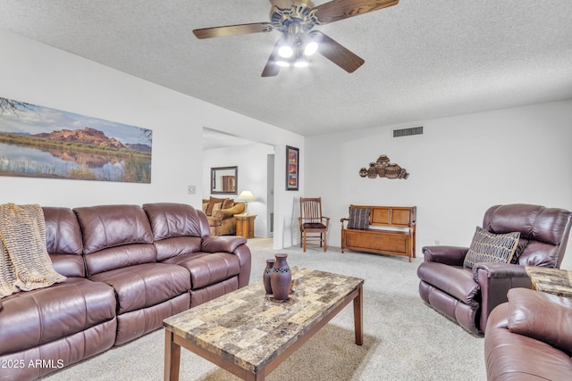 living room featuring light carpet, visible vents, and a textured ceiling