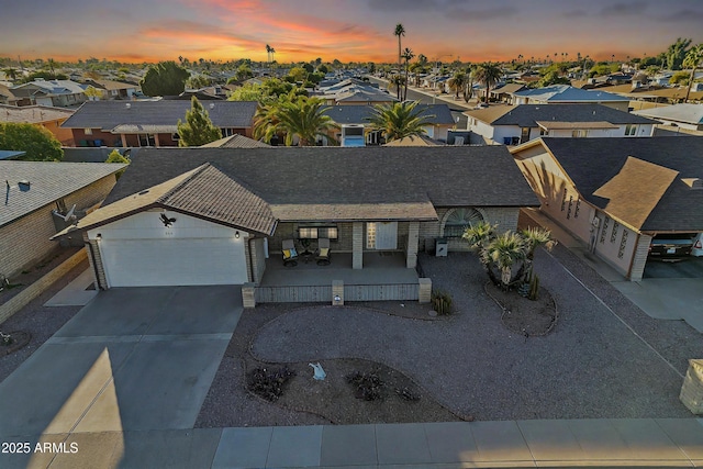 view of front of home with concrete driveway, an attached garage, and a residential view