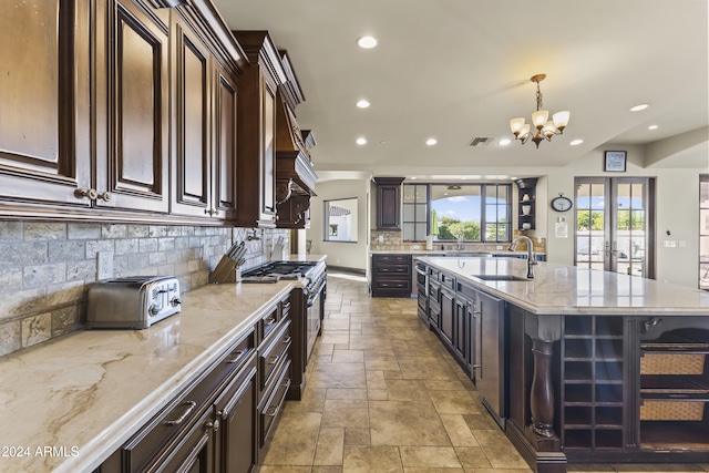 10125 E Cortez Dr, Scottsdale, AZ 85260 - kitchen featuring range with gas cooktop, recessed lighting, a chandelier, tasteful backsplash, and stone tile floors