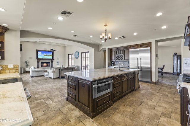 10125 E Cortez Dr, Scottsdale, AZ 85260 - kitchen featuring appliances with stainless steel finishes, arched walkways, stone tile floors, tasteful backsplash, and recessed lighting