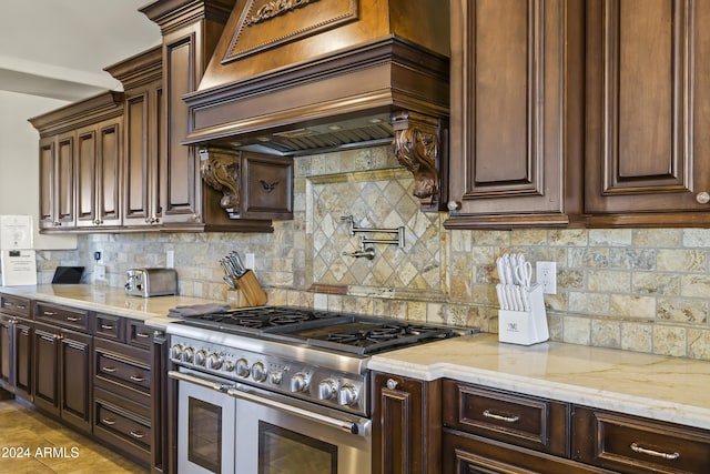 10125 E Cortez Dr, Scottsdale, AZ 85260 - kitchen with range with two ovens, custom exhaust hood, light stone counters, and tasteful backsplash