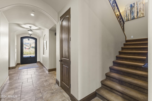 10125 E Cortez Dr, Scottsdale, AZ 85260 - foyer featuring arched walkways, stone tile floors, stairway, and vaulted ceiling