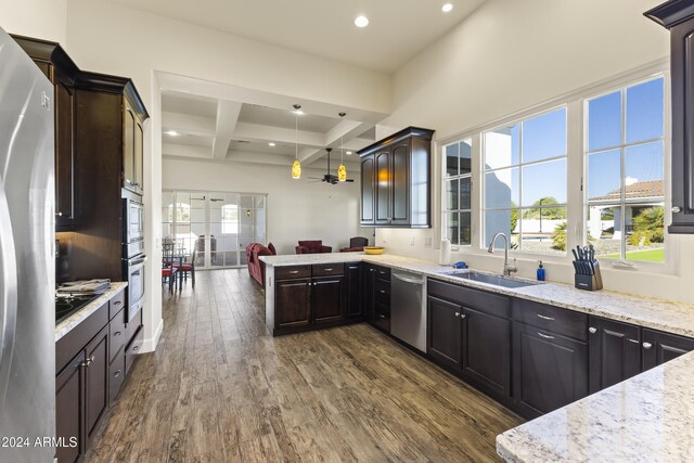 10125 E Cortez Dr, Scottsdale, AZ 85260 - kitchen featuring appliances with stainless steel finishes, coffered ceiling, dark wood-style flooring, beam ceiling, and light stone countertops