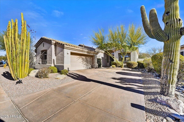 view of front facade featuring concrete driveway, a tiled roof, an attached garage, and stucco siding