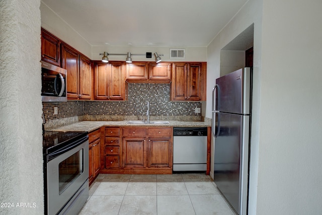 kitchen featuring decorative backsplash, appliances with stainless steel finishes, light tile patterned flooring, and sink