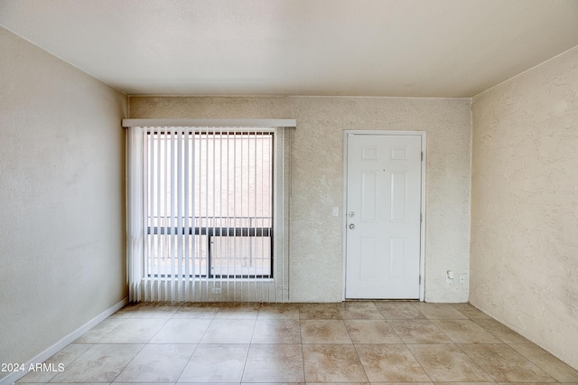 tiled empty room featuring ceiling fan