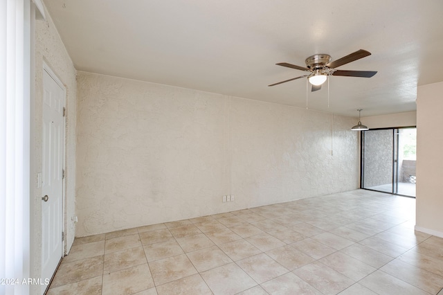 spare room with ceiling fan and light tile patterned floors