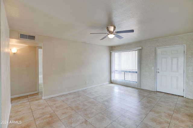 tiled empty room featuring ceiling fan