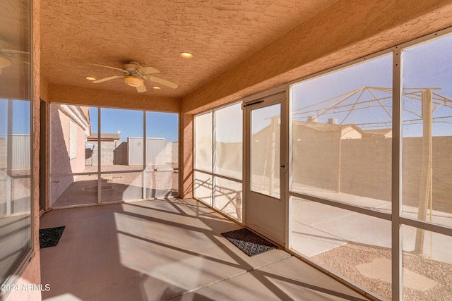 unfurnished sunroom featuring ceiling fan