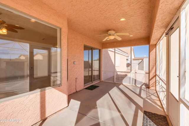 unfurnished sunroom with ceiling fan