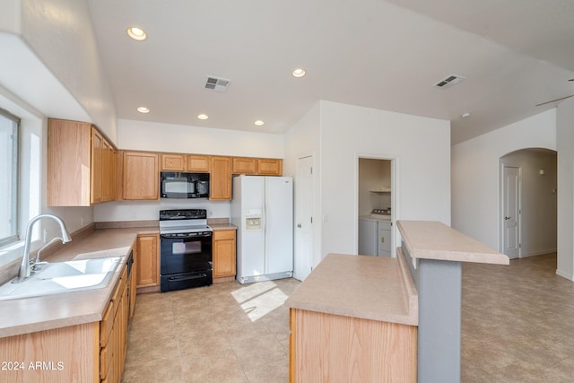 kitchen with a kitchen island, sink, separate washer and dryer, and black appliances