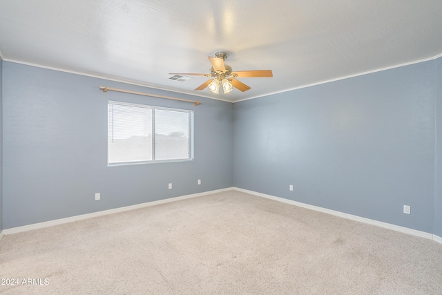 empty room featuring ornamental molding, ceiling fan, and carpet