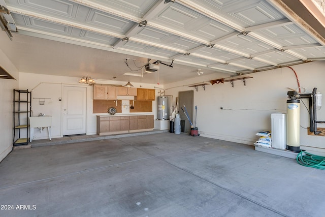 garage featuring a garage door opener, sink, and water heater