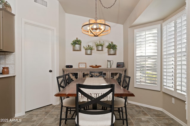 dining area with baseboards, visible vents, and an inviting chandelier