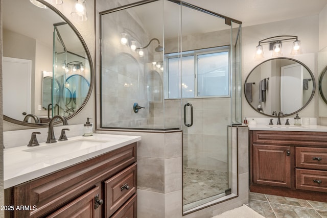 bathroom featuring a shower stall, two vanities, and a sink