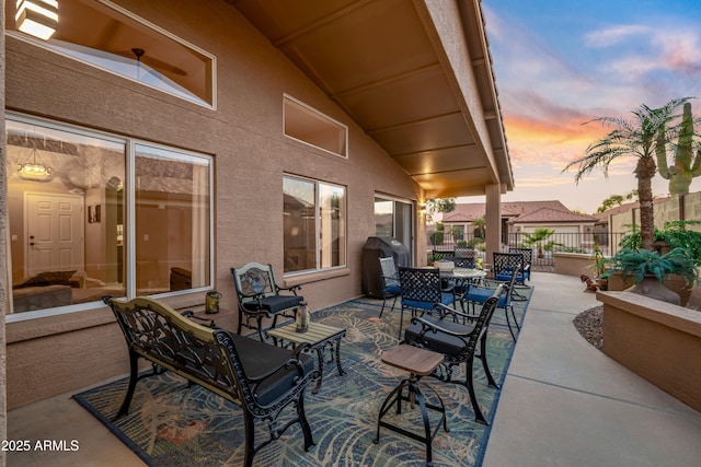 patio terrace at dusk with area for grilling and fence