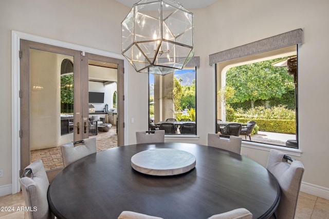 tiled dining room with an inviting chandelier