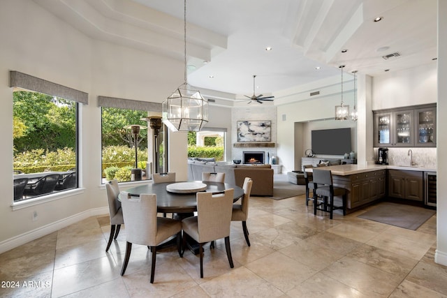 dining space with plenty of natural light, beamed ceiling, sink, and ceiling fan