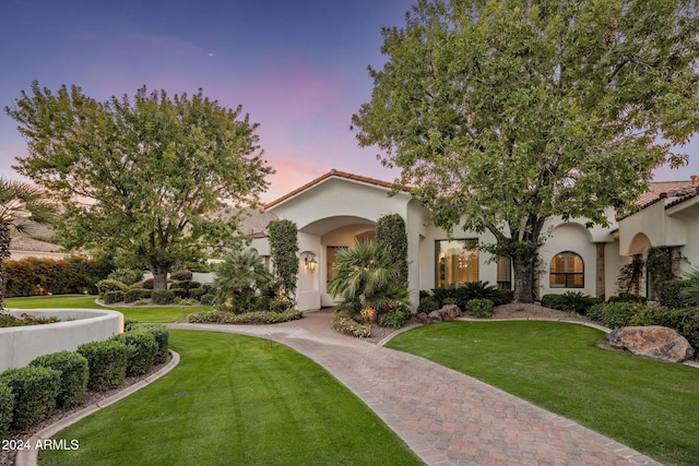 mediterranean / spanish-style home featuring a lawn