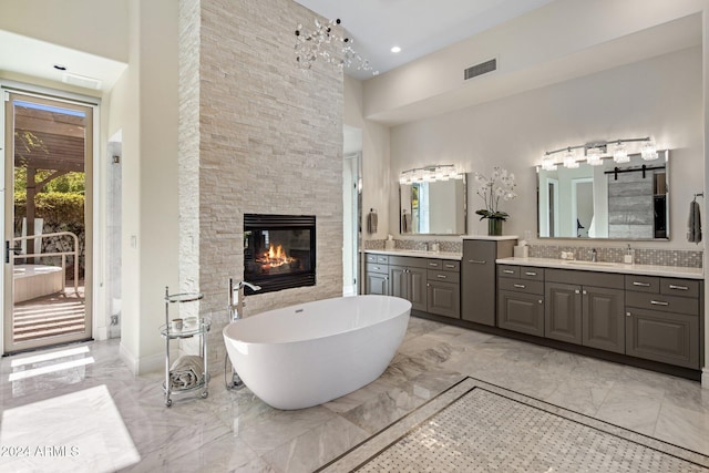 bathroom with a fireplace, vanity, and a high ceiling