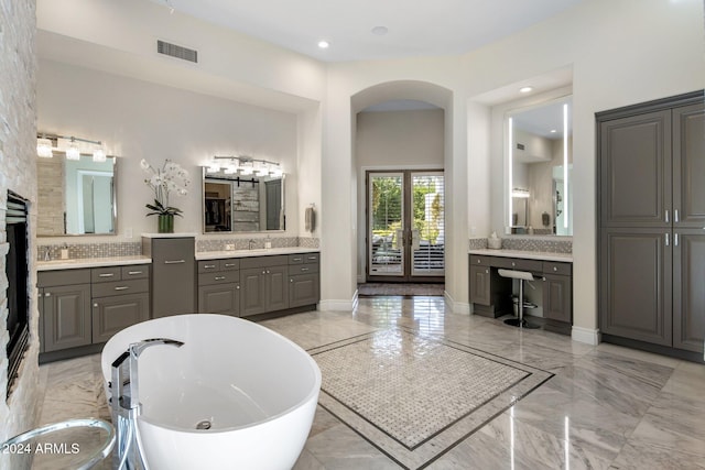 bathroom featuring a tub to relax in, vanity, and decorative backsplash