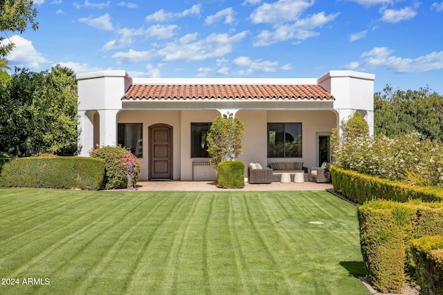 rear view of property featuring outdoor lounge area and a lawn