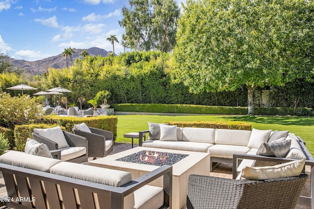 view of patio featuring a mountain view and an outdoor living space with a fire pit