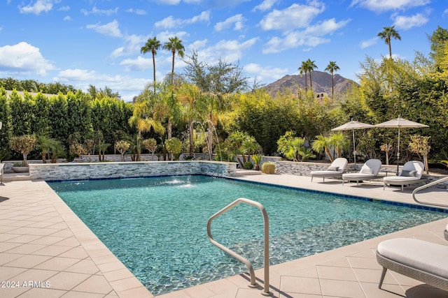 view of pool with a patio, a mountain view, and pool water feature