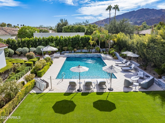 view of pool featuring a lawn, a mountain view, a patio, and pool water feature