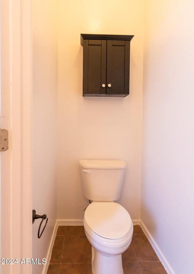 bathroom featuring toilet, baseboards, and tile patterned floors