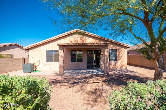 back of property with central AC unit, a fenced backyard, and stucco siding