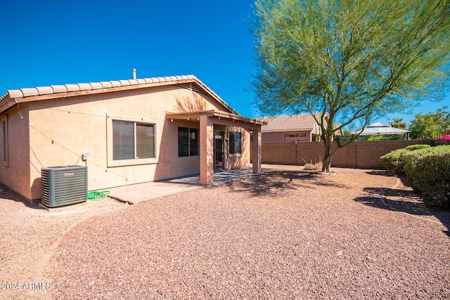 rear view of property with a tiled roof, fence, central air condition unit, a patio area, and stucco siding