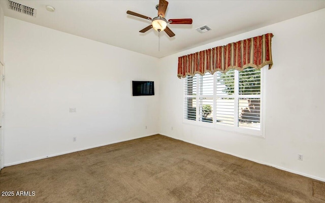 empty room featuring ceiling fan and dark carpet