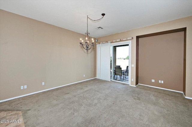 carpeted empty room featuring a notable chandelier