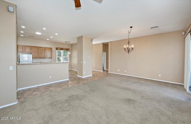 unfurnished living room featuring ceiling fan with notable chandelier and light carpet